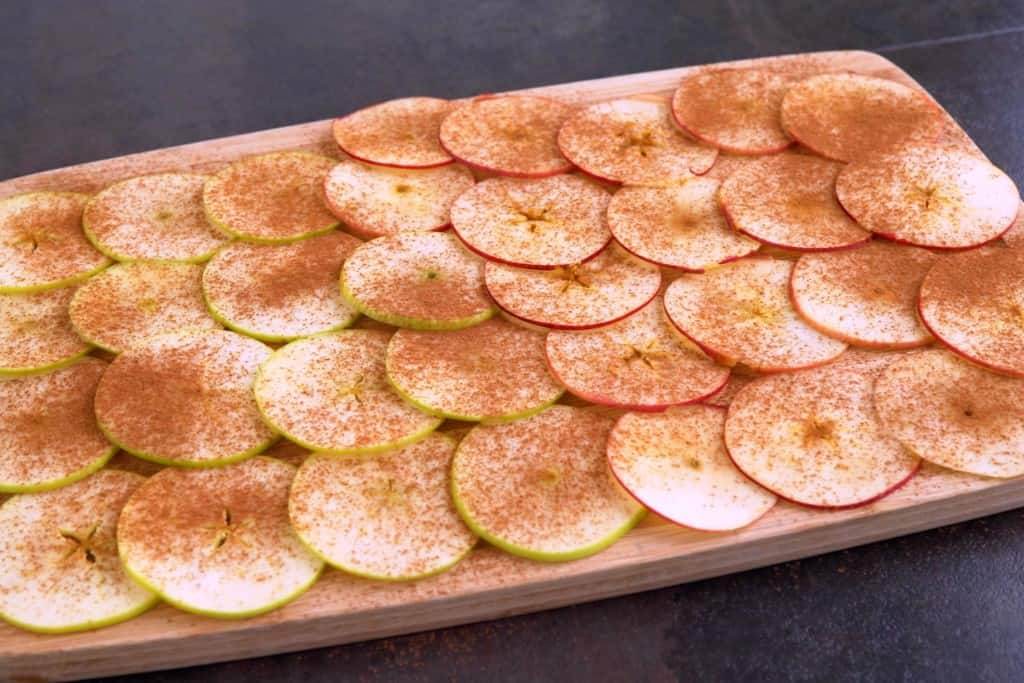 Lay out apple slices and sprinkle with cinnamon, to taste.