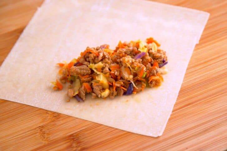 Place wrapper on a flat surface oriented in a diamond shape. Scoop filling mixture onto wrapper near top corner.