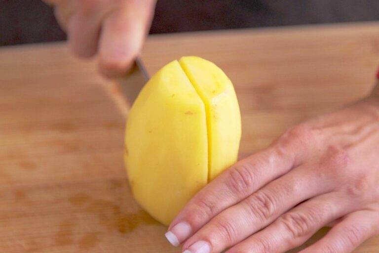 Cut off both ends of the potato, then cut in half.