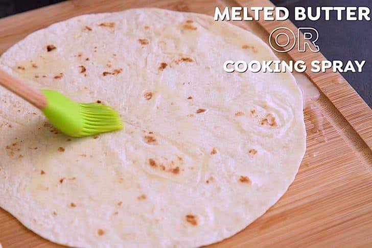 Brush one side of tortilla with melted butter or spray lightly with cooking spray.