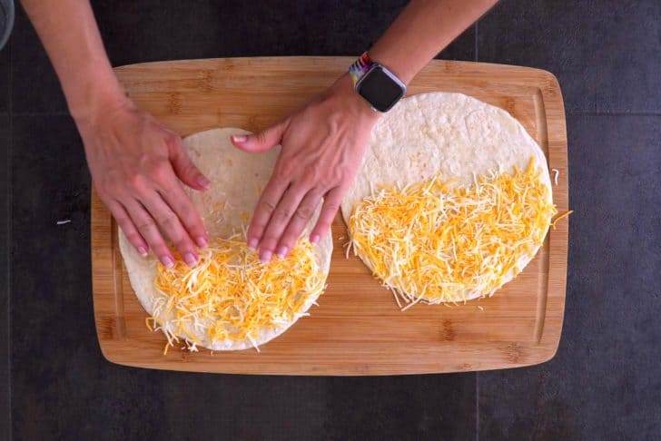Flip tortilla so buttered side is down, then fill with cheese and any additional desired fillings.