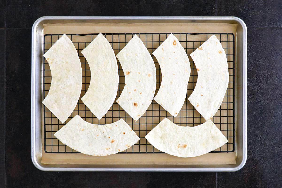 Arrange tortilla pieces on a wire baking rack on a lined baking sheet.