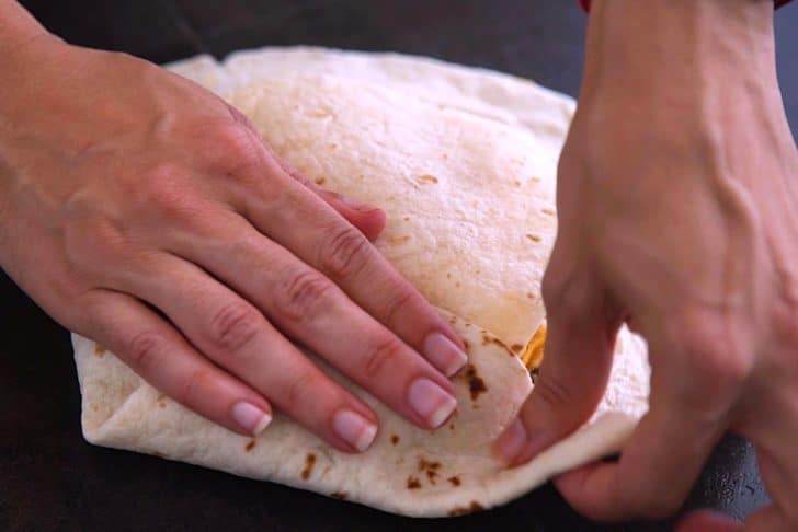 Press down the folded edge, then fold up the next edge and create "pleats" all the way around, until sealed.