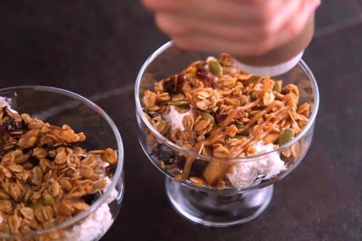 In trifle glasses, layer in cooked apples, granola, whipped cream, and date caramel.