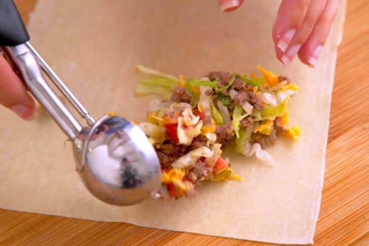 Once filling mixture has cooled, scoop onto egg roll wrapper and roll up tightly. Keep unused wrappers covered with a damp cloth to prevent drying out.