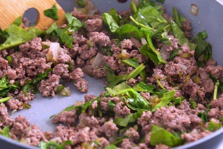Cook ground beef and combine with relish, spinach, and seasonings.