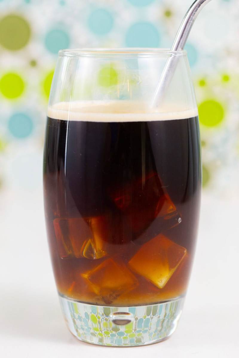 An iced coconut water americano on a white table