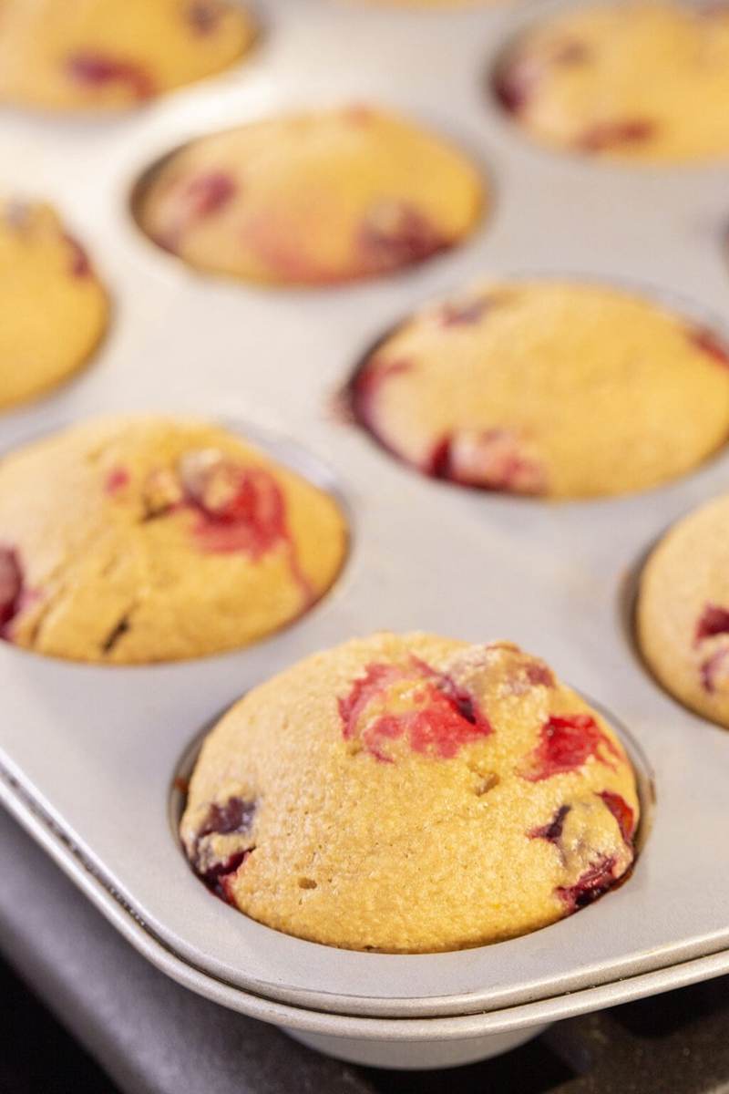 Baked cranberry orange blender muffins inside a muffin tin.