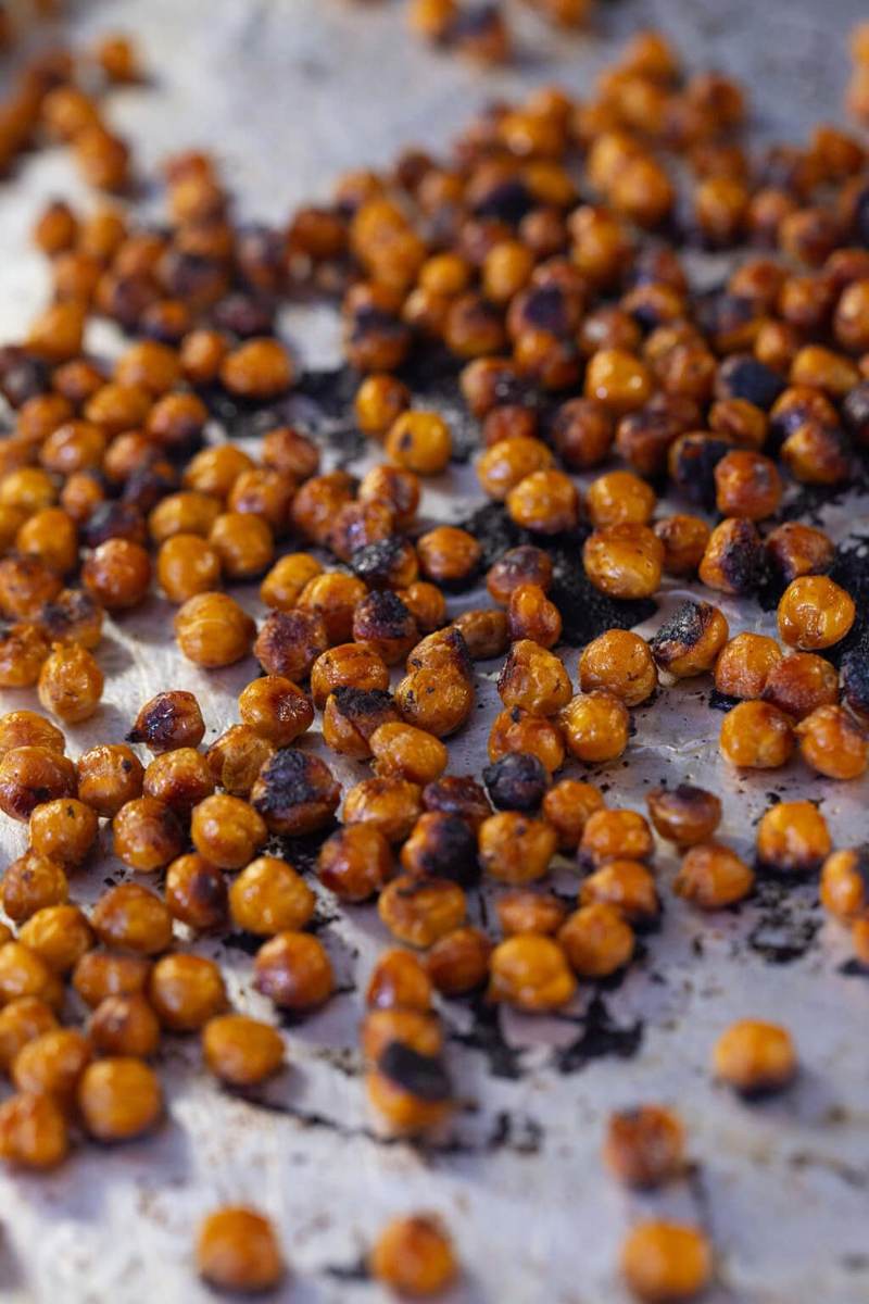 Crispy Asian-style roasted chickpeas spread on a foil lined baking sheet with caramelized edges.