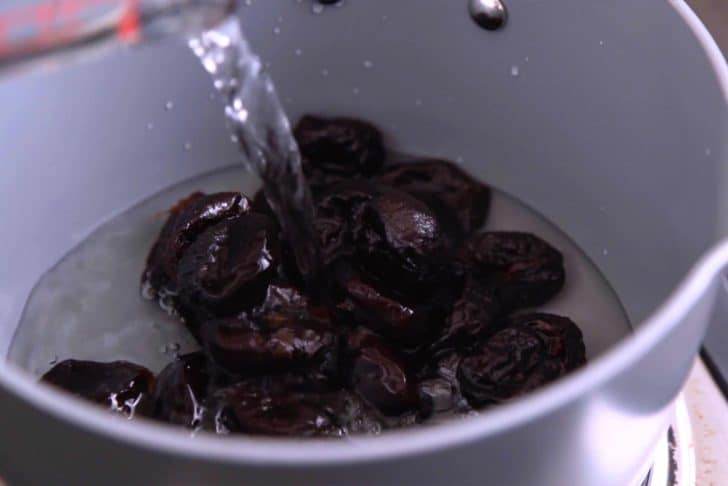 Add prunes and water to a saucepan over low heat.