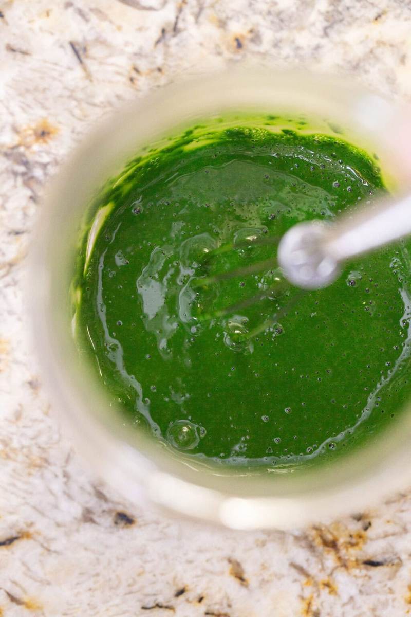 An overhead shot of whisking the iced matcha latte ingredients in a glass jar.