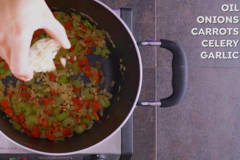 Saute onion, oil, and carrot in a deep pot for 7-8 minutes, then add garlic and saute for an additional minute.