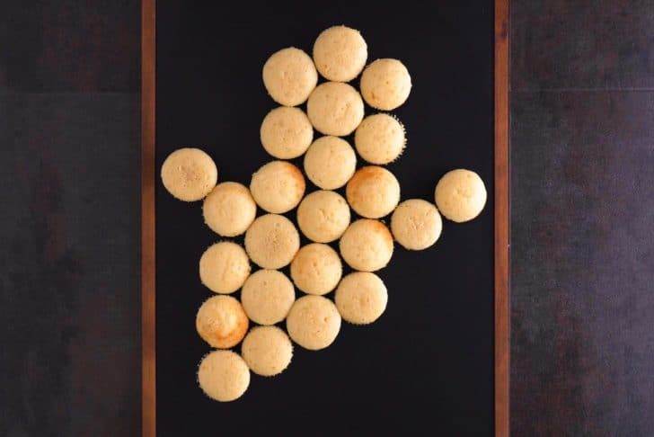 Arrange cooled cupcakes on a platter in a ghost shape.