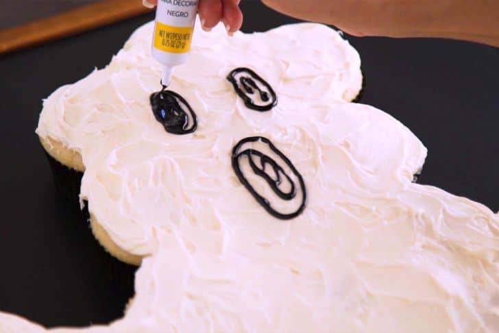 Use black decorating gel to draw on a ghost face and fill it in.