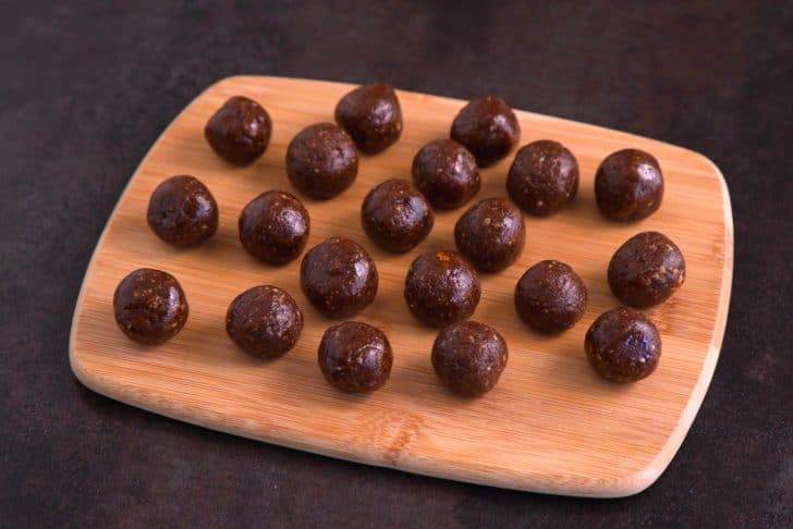 Use a cookie scoop to portion pecan date truffles and roll them into balls with your hands. Transfer to a plate or tray and freeze for 15 minutes, until firm.