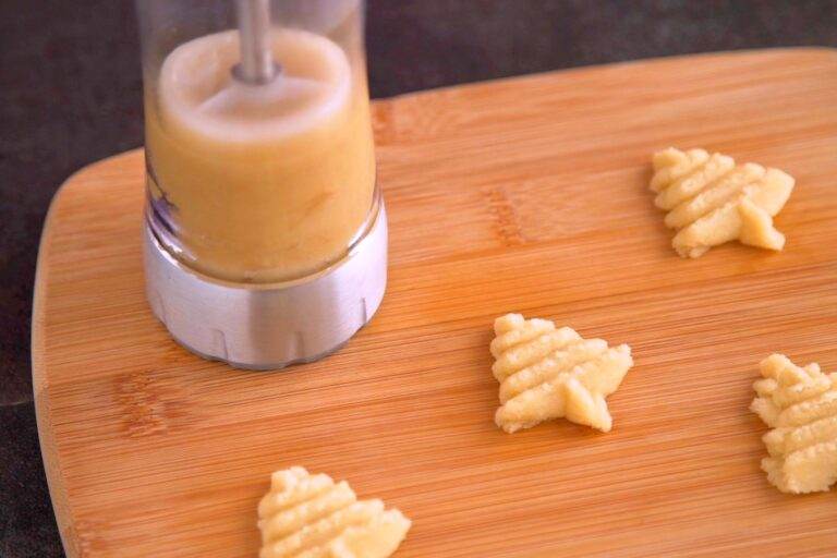 Pipe cookies onto a flat surface, laying the cookie press flat against the surface and pressing firmly.