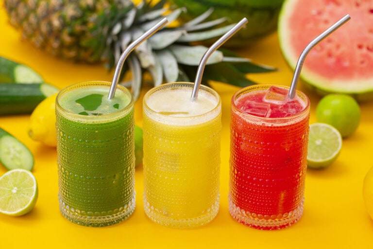Three glasses of agua fresca, cucumber, pineapple, and watermelon flavors.