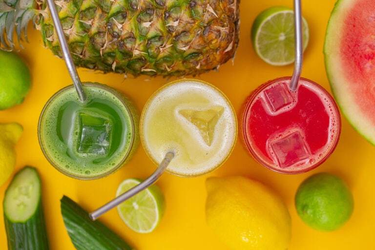 Three glasses of agua fresca lined up in a row, cucumber, pineapple, and watermelon flavors.