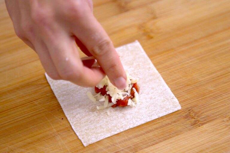 Fill a wonton wrapper with 1½-2 teaspoons of the sauce mixture and top with mozzarella cheese.