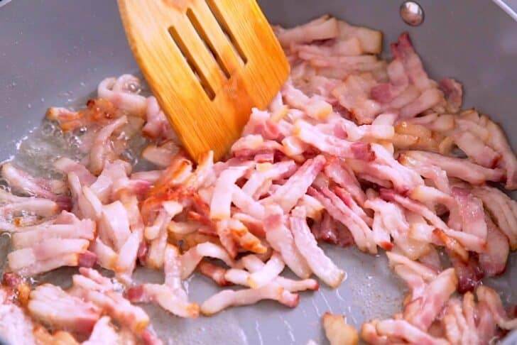 Add bacon crumbles to a hot pan to cook for 5-6 minutes.