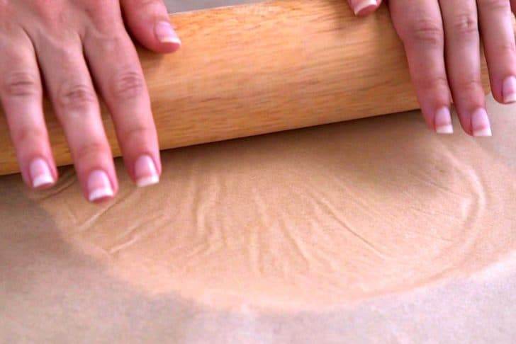 Place another sheet of parchment on top of dough and roll out with a rolling pin, until ~⅛-inch thick.