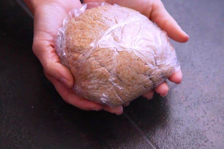 Form homemade Ritz cracker dough into a ball, wrap in plastic, and refrigerate for 15-30 minutes to firm up.