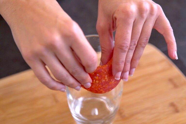 Fold meat slice in half over the rim of the glass & press to crease.