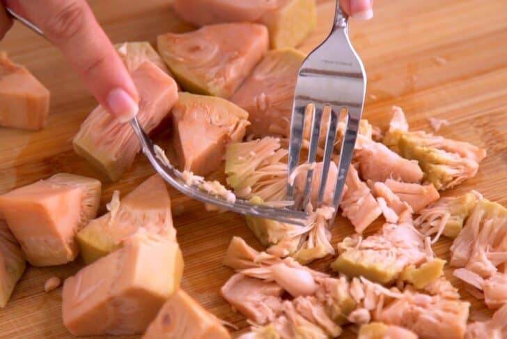 Drain and rinse canned jackfruit. Transfer to a cutting board and shred the jackfruit with 2 forks.