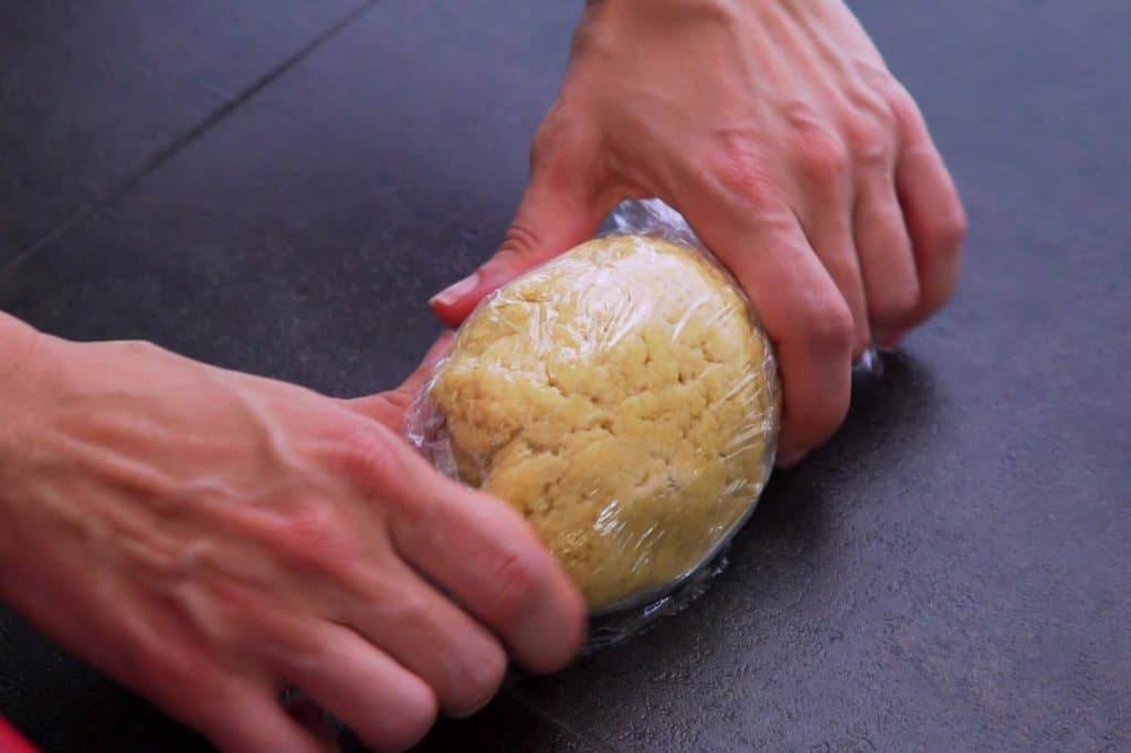 Shape keto tortillas dough into a ball, wrap in plastic, and refrigerate for at least 15 minutes.