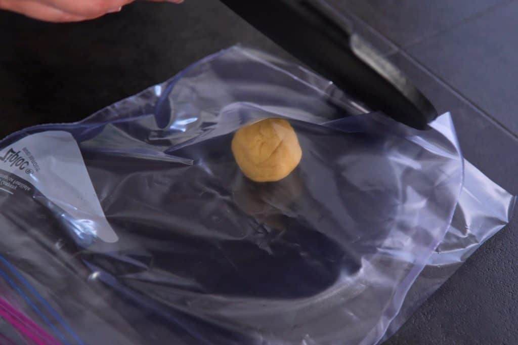 Line tortilla press with sheets of plastic before pressing each dough ball flat.