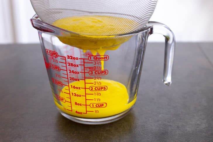 Strain blended juice through a fine mesh strainer, using a spatula to help move the juice through the strainer as needed.