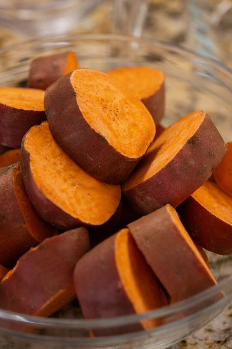 A glass bowl filled with sliced sweet potato rounds.
