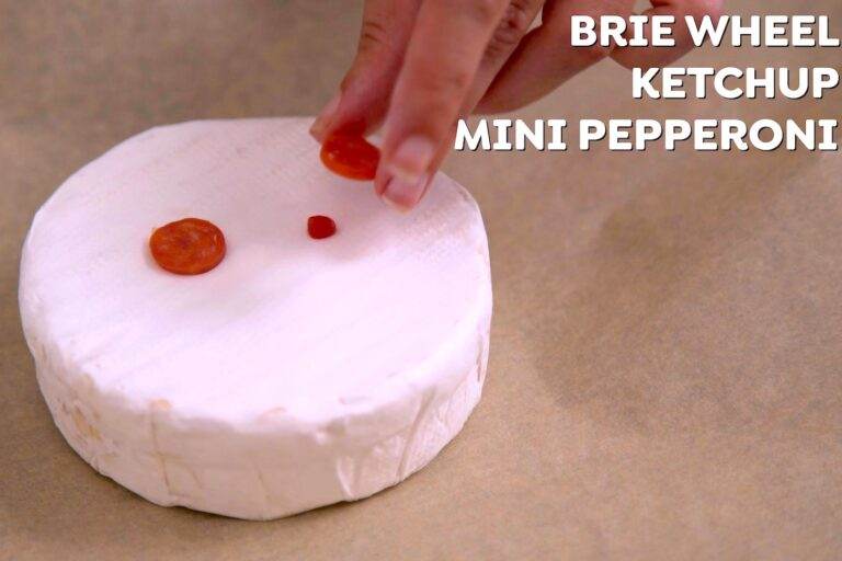 Place brie onto a parchment-lined baking sheet. Using dots of ketchup or hot sauce as glue, attach mini pepperonis as eyes. (Or skip the pepperoni and use olives only.)