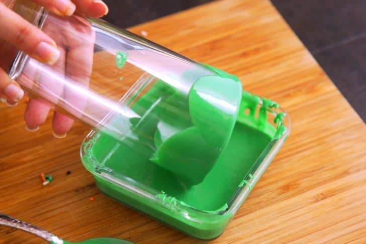 Dip lip of serving glass in melted green frosting, coating it all the way around the outer edge of the glass.