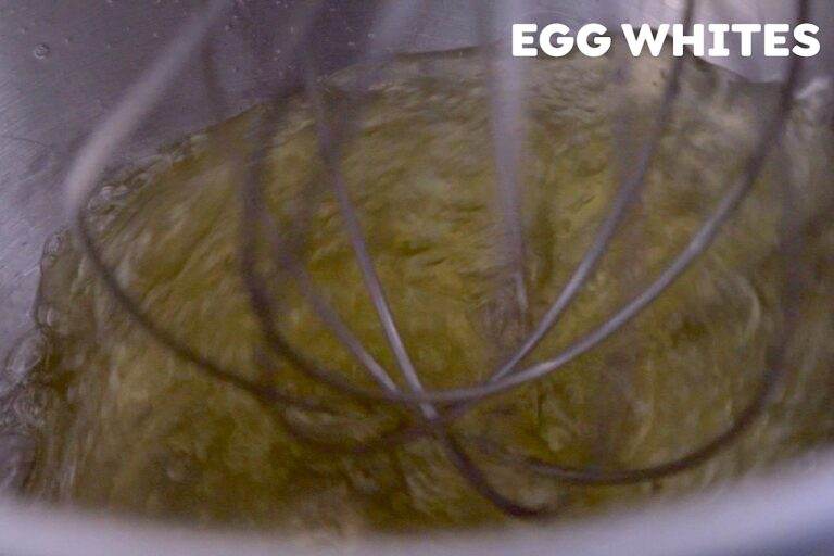 Add fresh egg whites to the bowl of a stand mixer and begin whipping on medium-high speed. The egg whites will look opaque and liquidy at first.