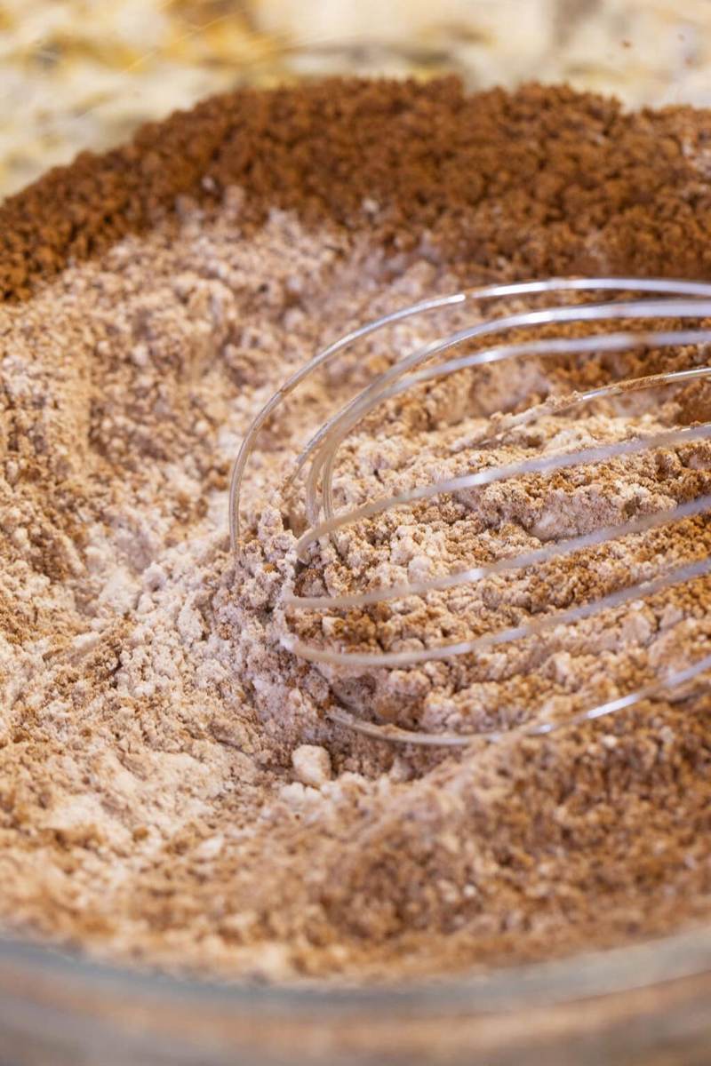 A whisk mixing dry ingredients in a bowl for peppermint mocha cookies.