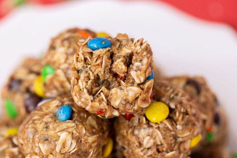 A close-up of a pile of no-date protein balls on a white plate, sitting on a red table setting.