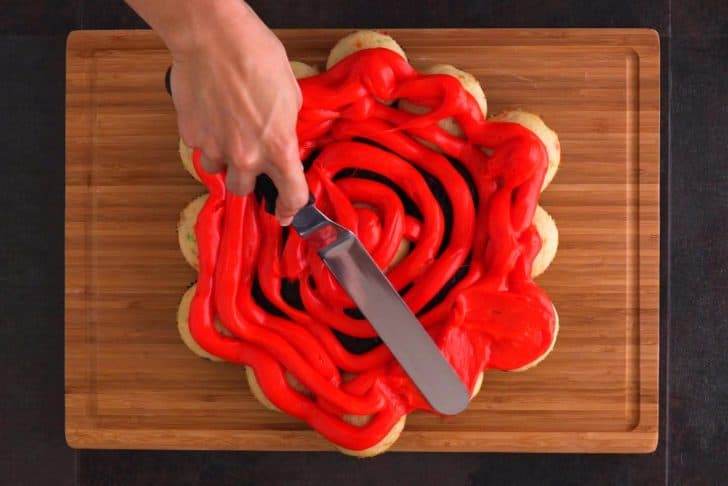 Add orange frosting liberally onto cupcakes—either squeeze the frosting from a decorating bag, or spread it straight from the tub. Spread evenly with an offset spatula.