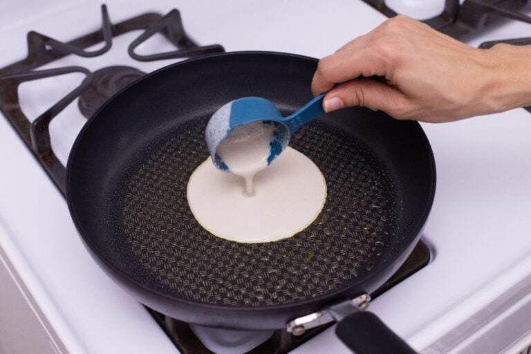 pouring gluten free tortilla batter into the pan