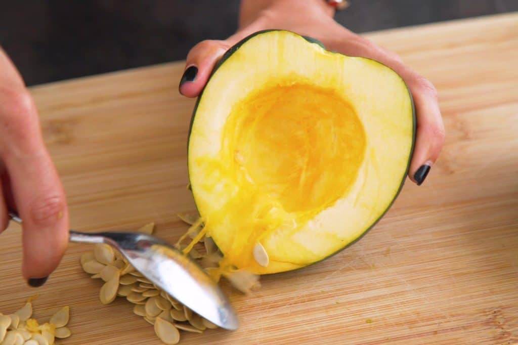 Scoop out acorn squash seeds