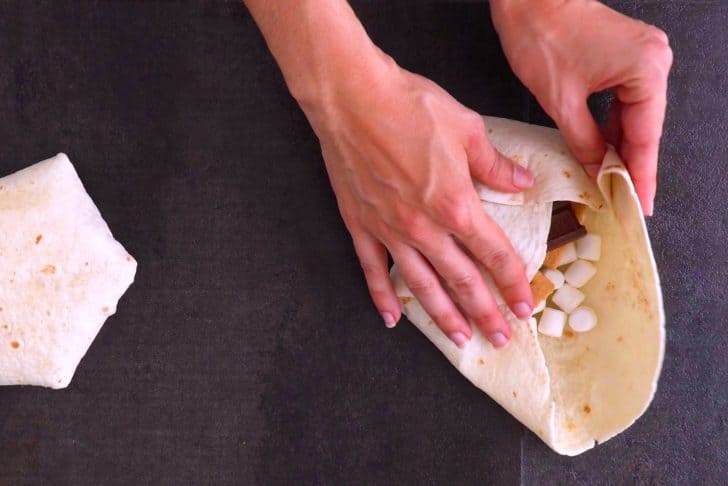 Press down the folded edge, fold up the next edge, and create "pleats" all the way around, until sealed.