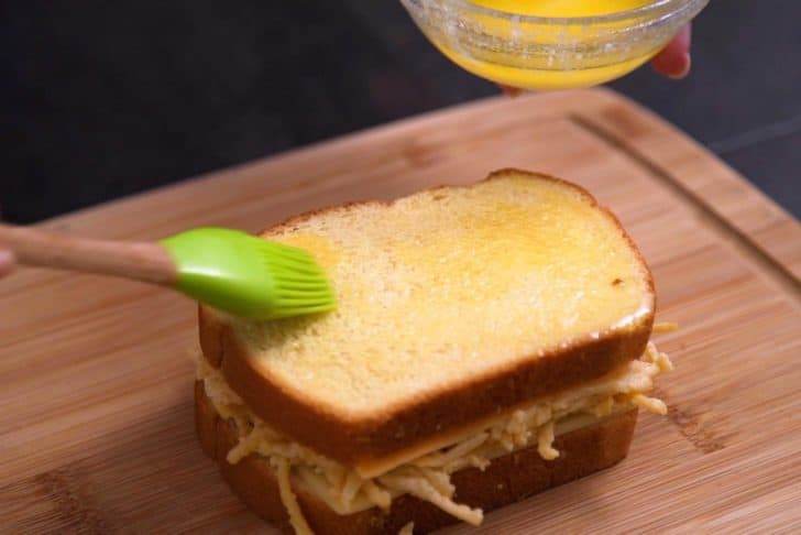 Brush melted butter onto bread before adding to hot pan or griddle.