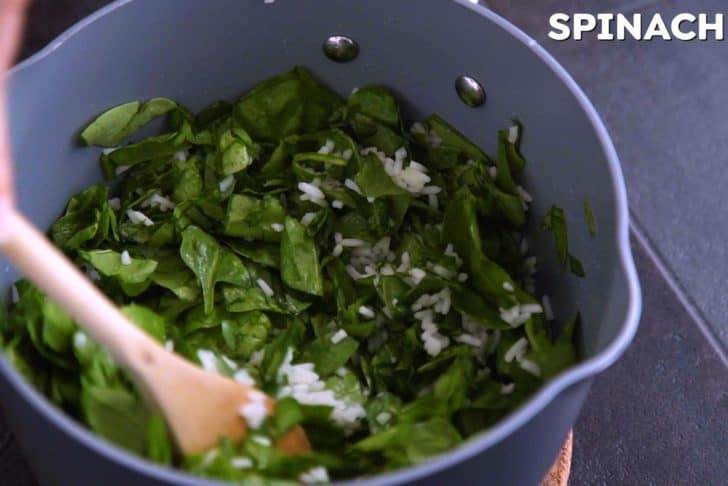Add chopped spinach to cooked rice, cover, and allow to wilt.