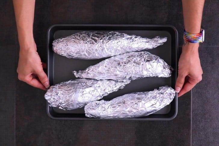 Wrap each sweet potato in foil, place on a baking sheet, and roast at 400°F (200°C) for 45-60 minutes, until tender.