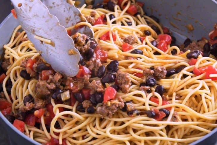Toss cooked spaghetti noodles with taco mixture to combine.