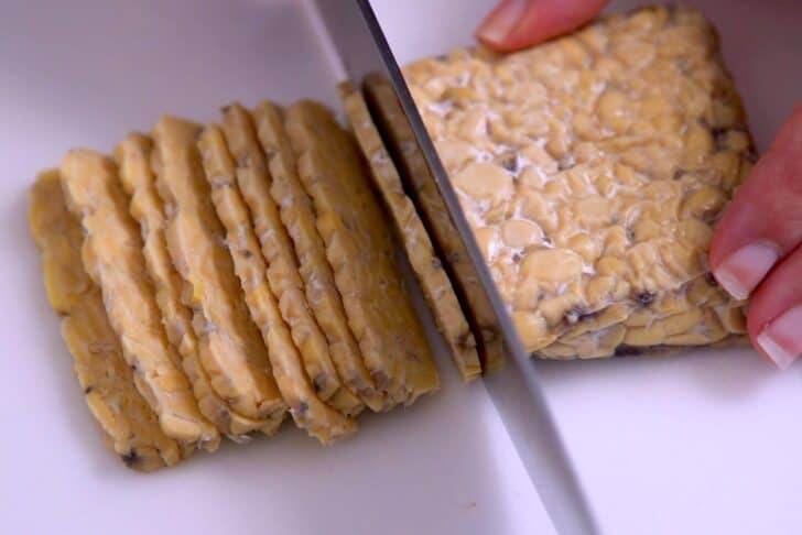 Slice tempeh into thin strips, around 1/8-inch thick.