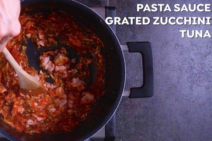 Heat pasta sauce and grated zucchini for 2-3 minutes, then add canned tuna to soften.