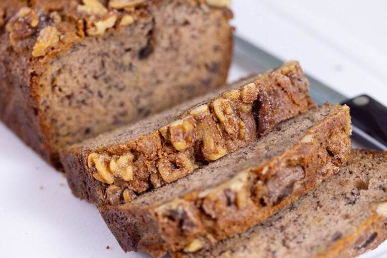 Slices of banana bread on a white cutting board.