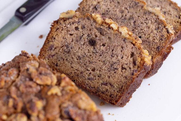 Slices of banana bread on a white cutting board.