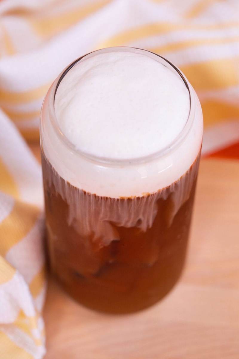 A glass of iced coffee topped with vanilla sweet cream cold foam.